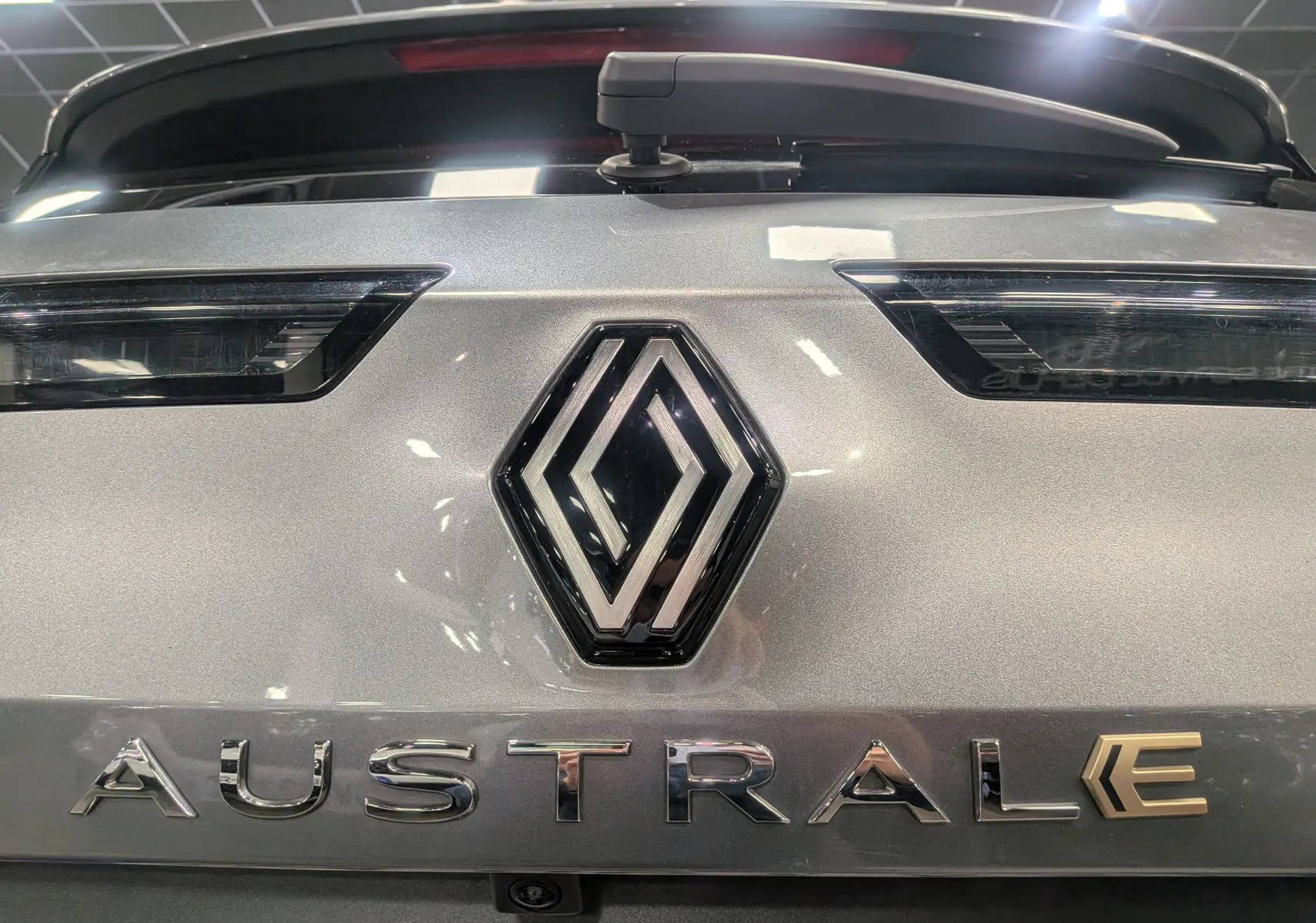 Gros plan sur l'arrière gris schiste du Renault Austral 2024 avec logo et lettres chromées distinctives E-Tech.