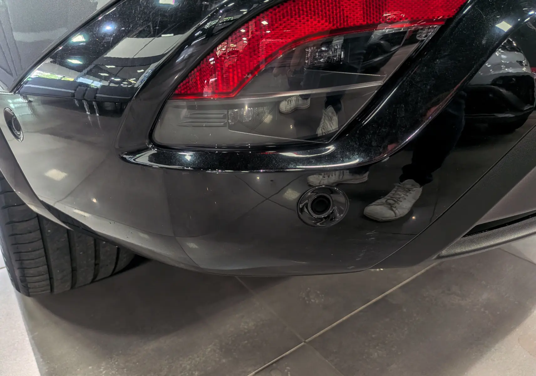 Gros plan sur le feu arrière droit gris schiste du Renault Austral E-TECH 2024, avec capteur de stationnement visible.