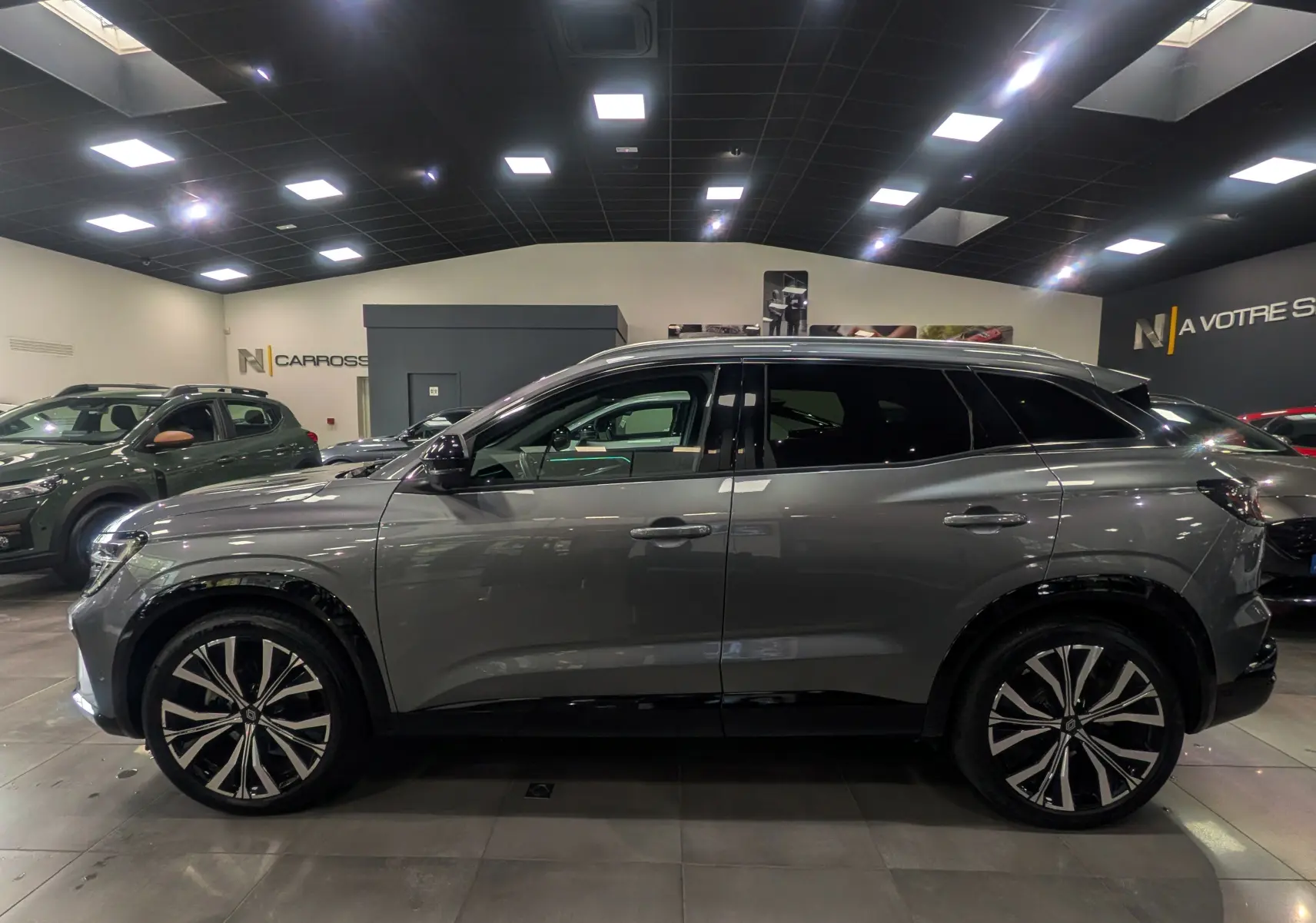 Profil côté gauche du Renault Austral E-TECH gris schiste 2024 en finition ICONIC avec jantes biton élégantes.