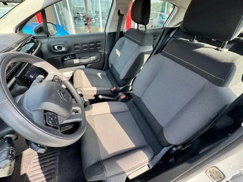 Intérieur avant de la Citroën C3 1.2 Shine 2021, sièges tissu Mica Grey et volant cuir vu côté conducteur.