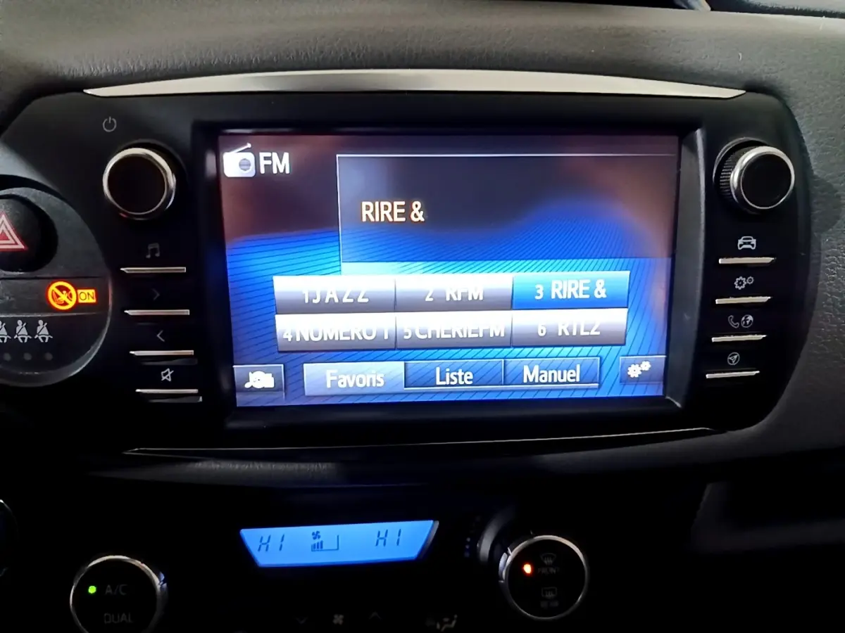 Vue rapprochée de l’écran tactile central multimédia de la Toyota Yaris 2019 avec commandes climatisation et boutons latéraux.