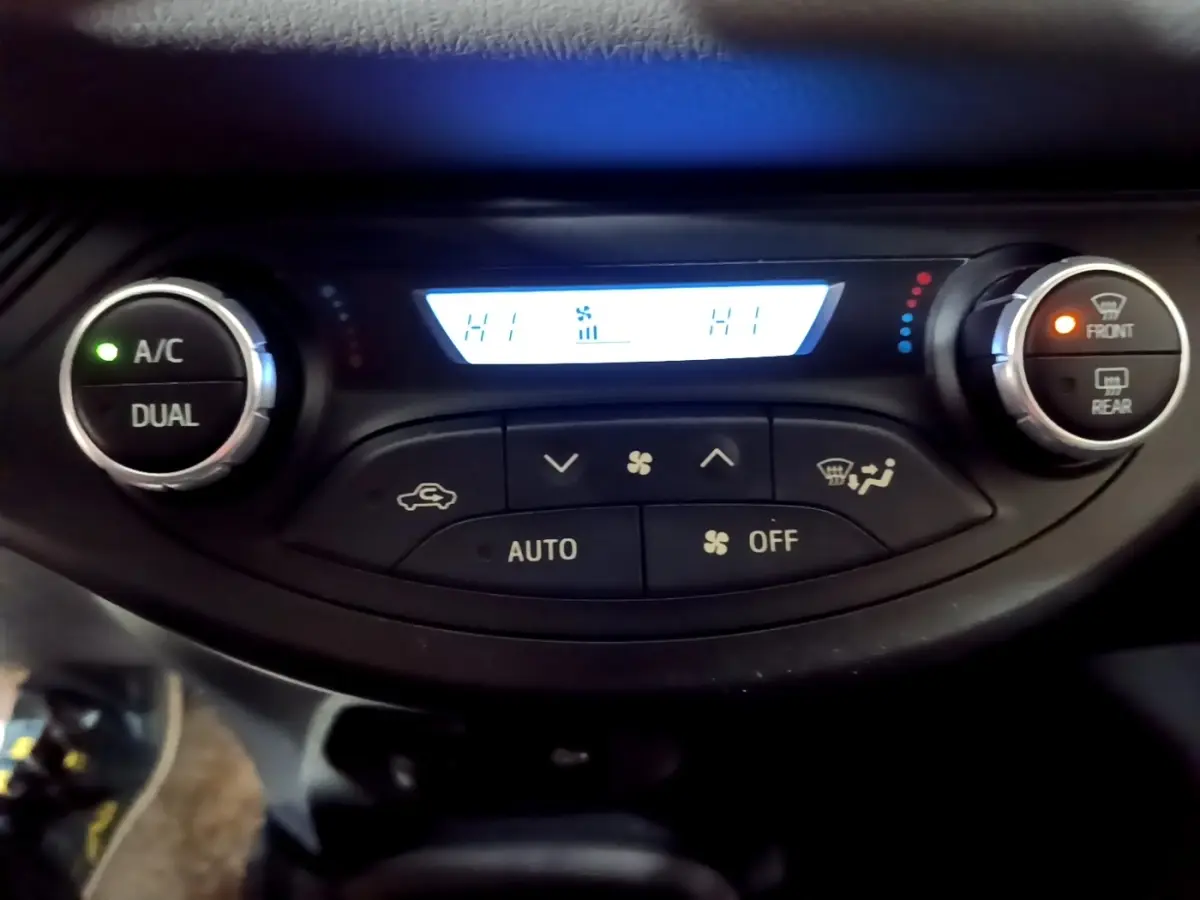 Panneau de commande de la climatisation 2 zones de la Toyota Yaris blanche, affichage digital avec boutons rotatifs.