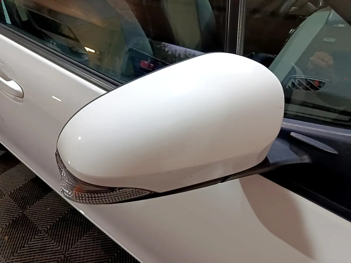 Gros plan sur le rétroviseur droit blanc de la Toyota Yaris 1.5 VVT-I HYBRID France Business 2019.