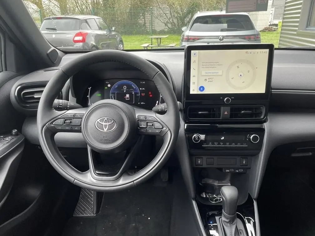 Vue intérieure frontale du tableau de bord noir et volant cuir de la Toyota Yaris Cross 1.5 Hybrid 130h Design Auto.