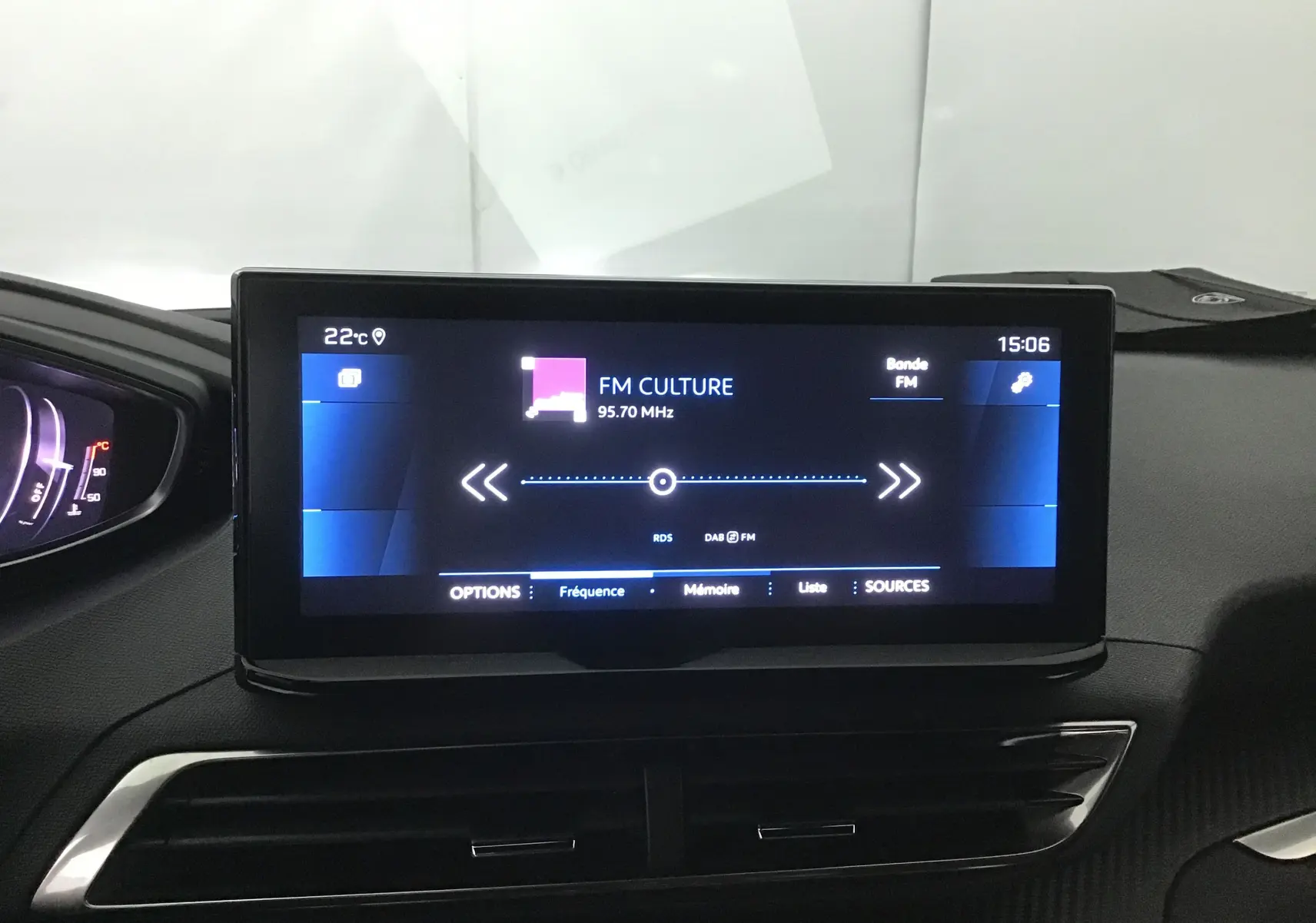 Écran central tactile du tableau de bord du Peugeot 5008 2024 affichant une radio FM sur fond noir.