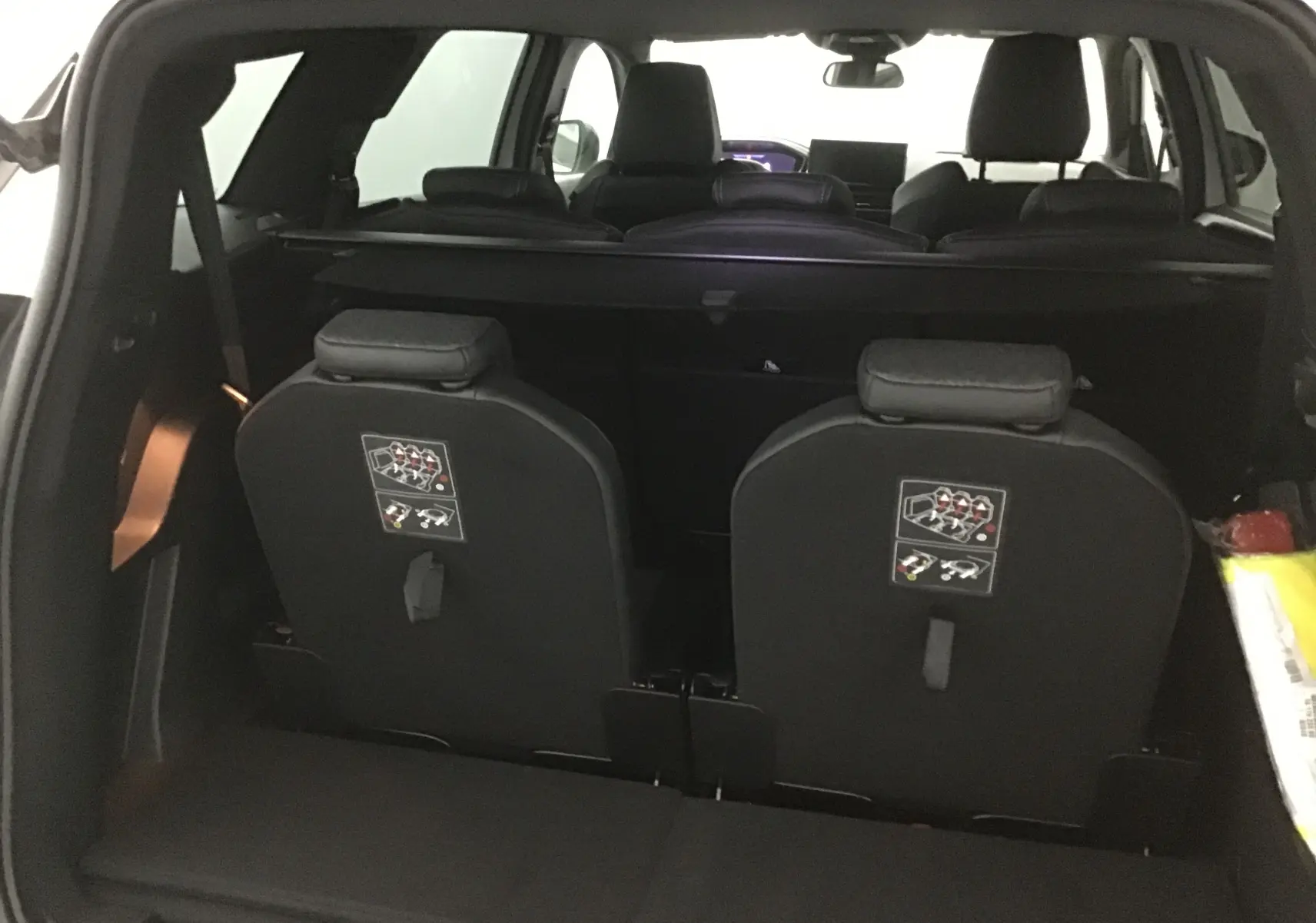 Vue arrière intérieure du Peugeot 5008 blanc nacré 2024, montrant les sièges rabattus de la troisième rangée.