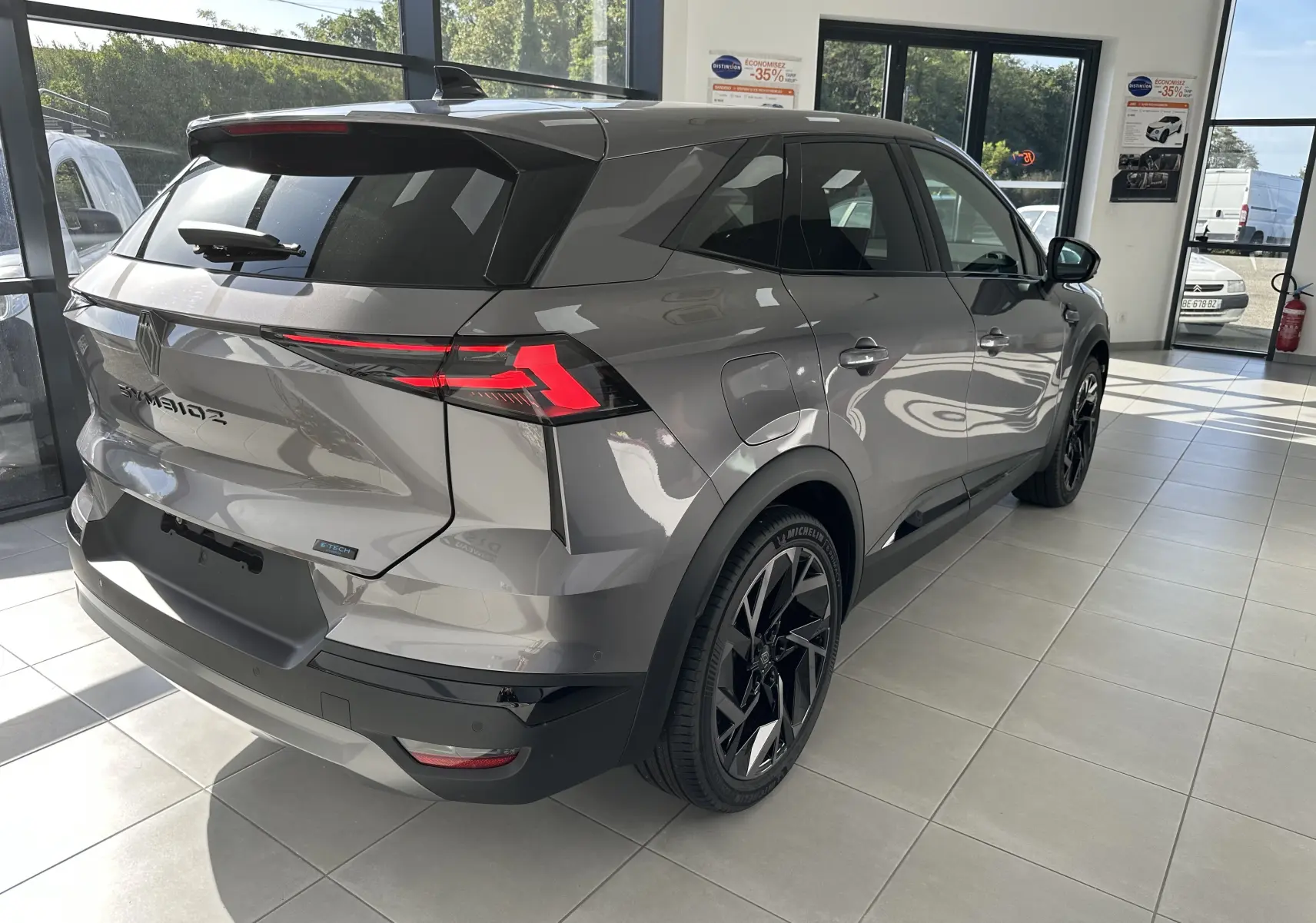 Vue 3/4 arrière droite du Renault SYMBIOZ Esprit Alpine gris Cassiopée, avec feux LED et jantes noires distinctives.