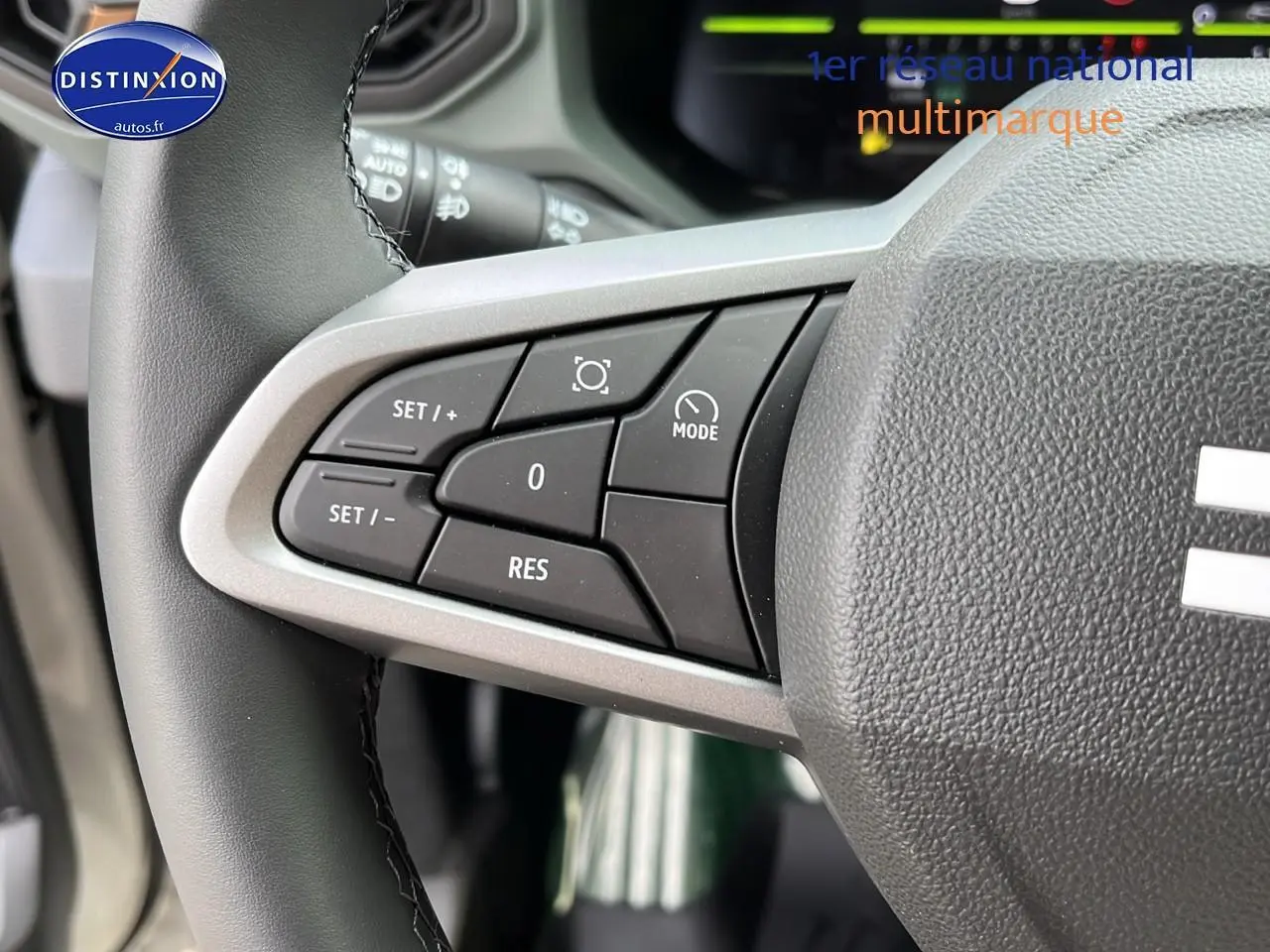 Gros plan sur les commandes du régulateur de vitesse au volant du Dacia Duster 2025 couleur Sandstone.