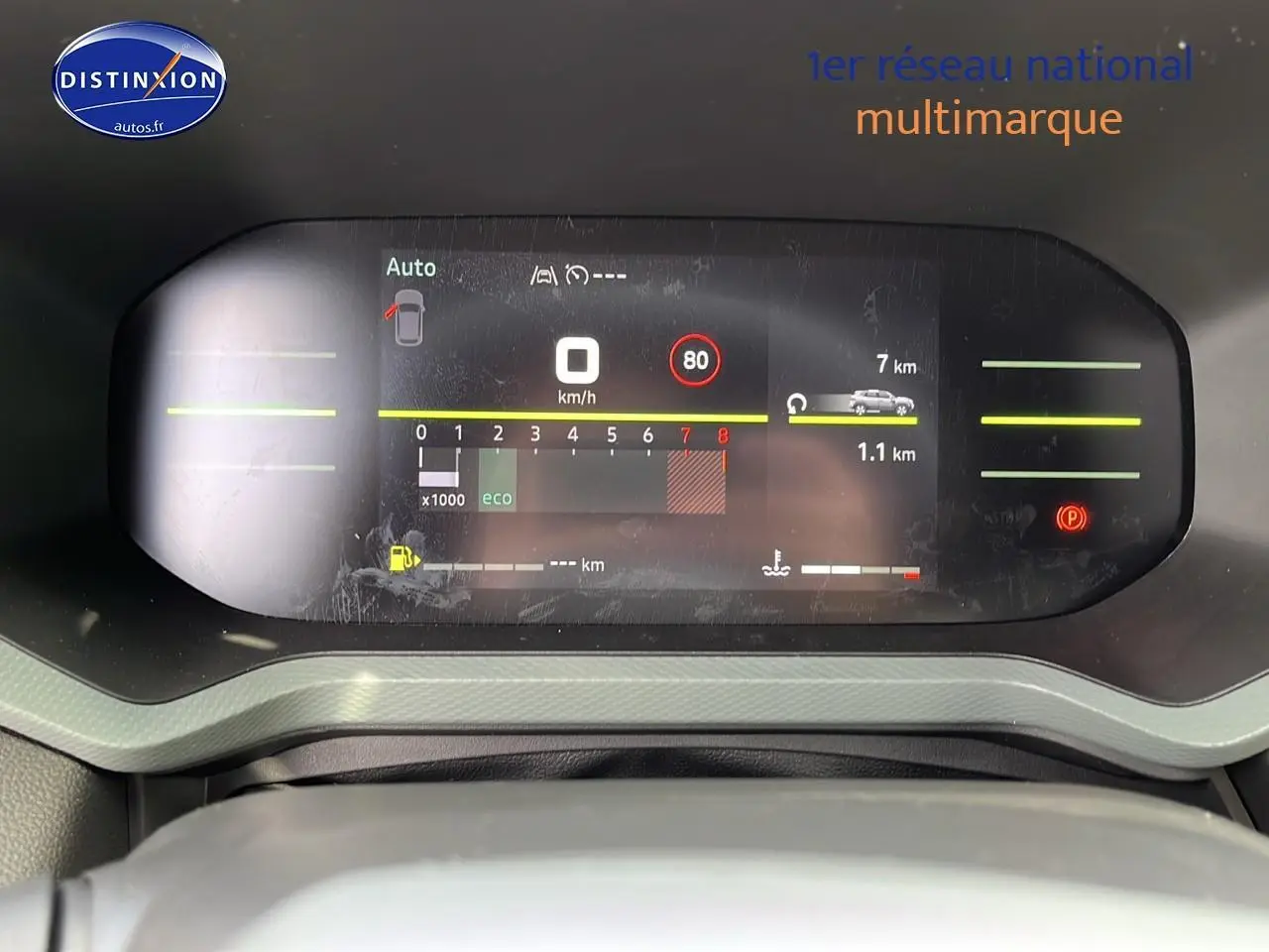 Tableau de bord numérique du Dacia Duster 2025 affichant vitesse, régime moteur et alertes, vue frontale rapprochée.
