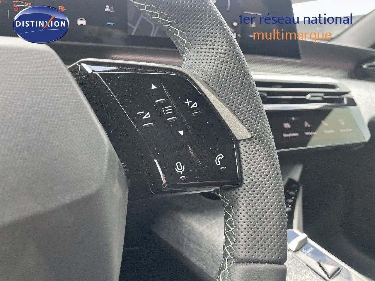 Gros plan sur la partie gauche du volant en cuir perforé noir avec commandes tactiles du Peugeot 5008 Hybrid 2025.