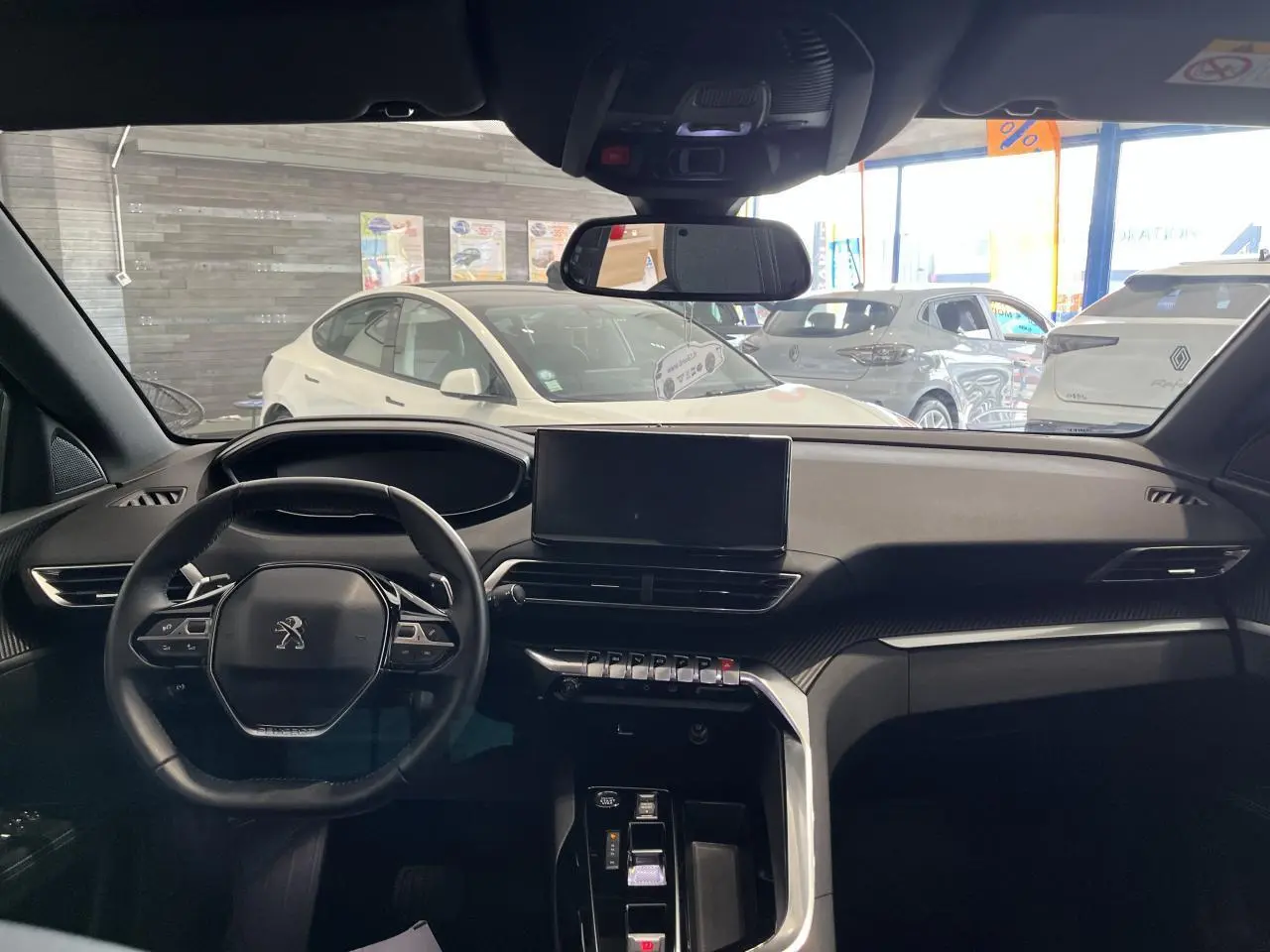 Intérieur noir du Peugeot 5008 2024 vu de face, avec tableau de bord moderne et écran tactile central.