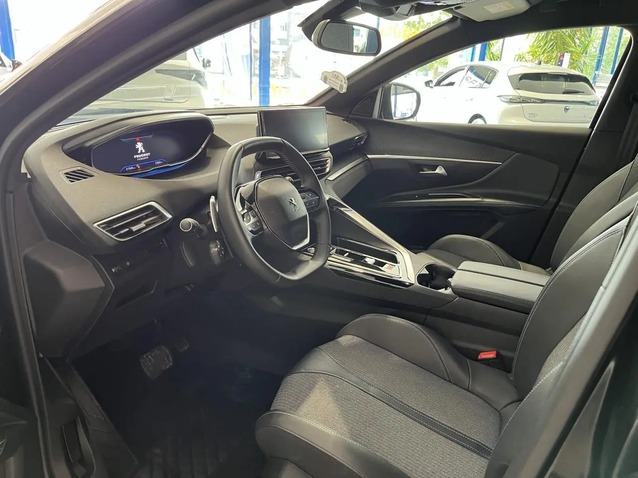 Intérieur avant droit du Peugeot 5008 2024 noir métallisé, volant compact, écran tactile et sellerie TEP & tissu Colyn.