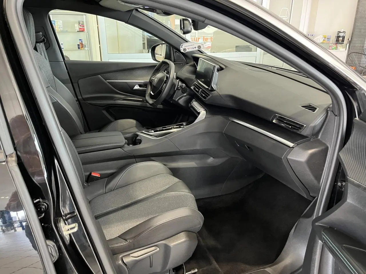Intérieur avant droit du Peugeot 5008 noir métallisé, tableau de bord moderne avec écran tactile et sellerie TEP & tissu.