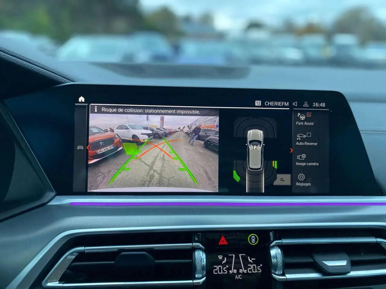Affichage de l'écran intérieur du BMW X5 blanc 2022 montrant la caméra de recul et l'assistance au stationnement.
