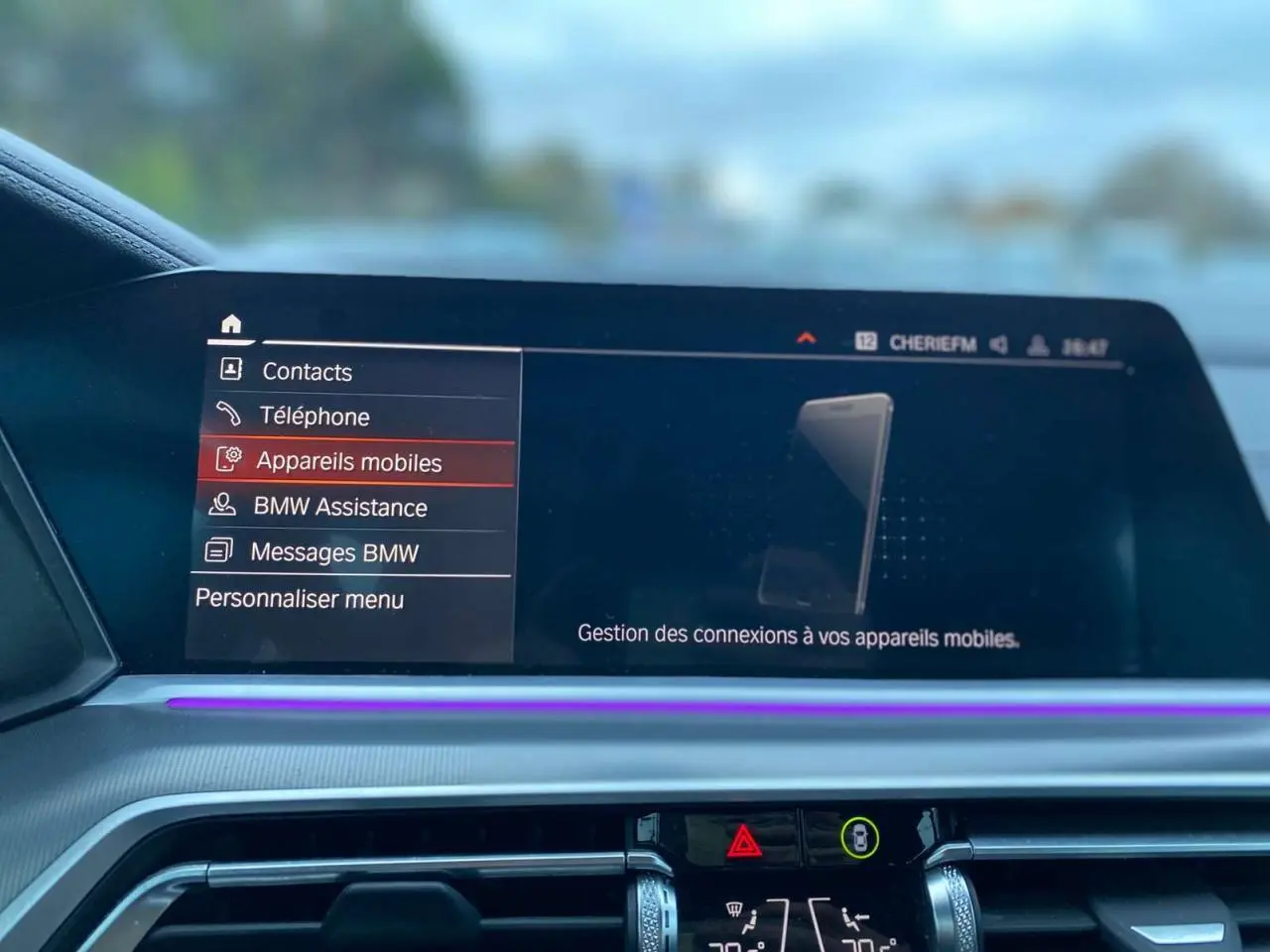 Écran central du tableau de bord du BMW X5 blanc 2022, affichant le menu de gestion des appareils mobiles.