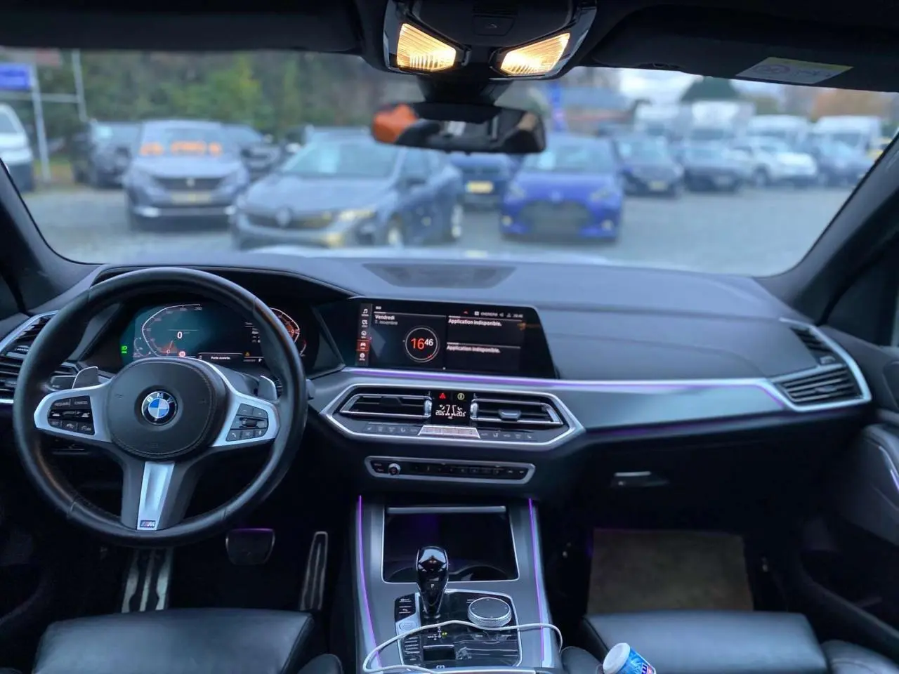 Intérieur du BMW X5 xDrive 30d 2022, tableau de bord et volant M Sport avec éclairage d'ambiance violet.