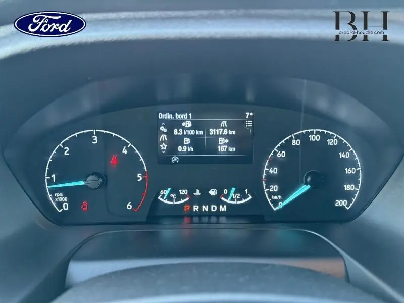 Vue rapprochée du tableau de bord numérique du Ford Transit Custom noir, affichant les compteurs et l'ordinateur de bord.