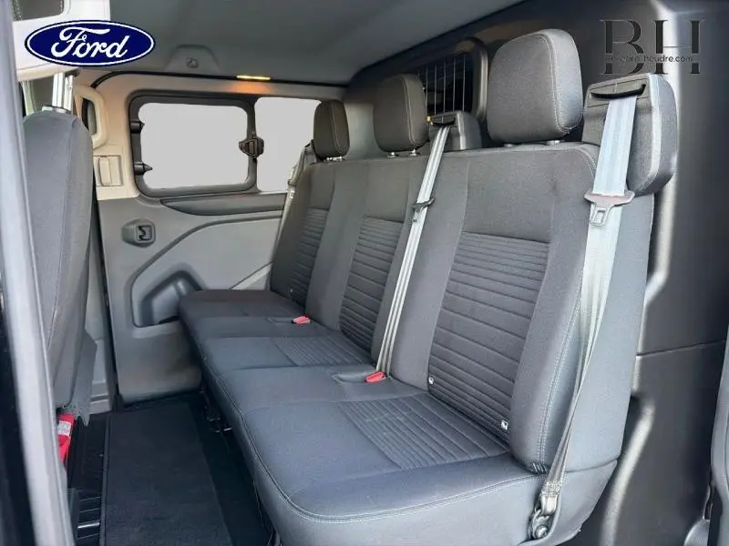 Vue intérieure côté droit de la banquette arrière noire du Ford Transit Custom Fourgon 2023 avec ceintures et vitres entrebaillantes.