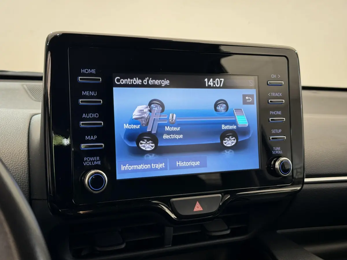 Écran tactile central affichant le contrôle d'énergie hybride dans l'habitacle d'une Toyota Yaris blanche.