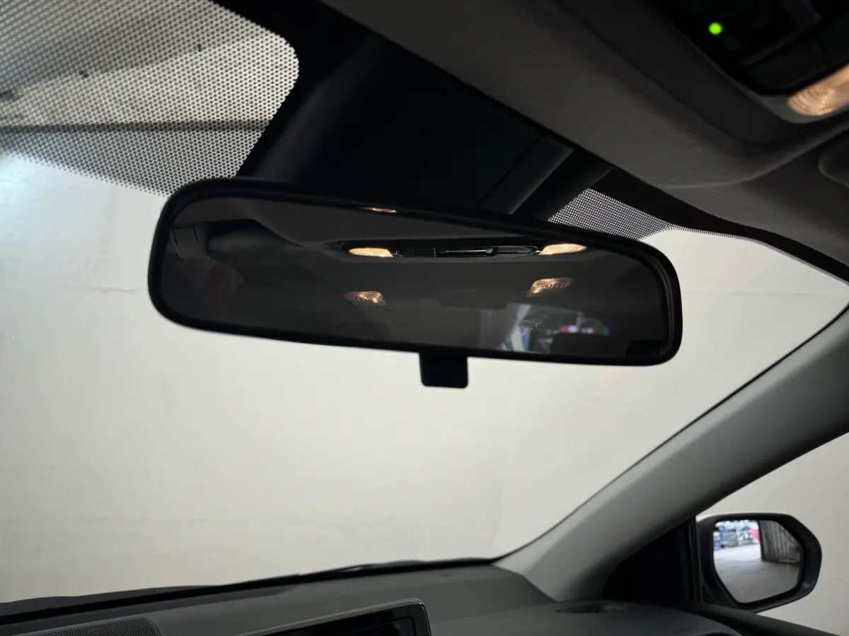 Vue intérieure du rétroviseur central de la Toyota Yaris hybride blanche 2022 avec éclairage intérieur allumé.