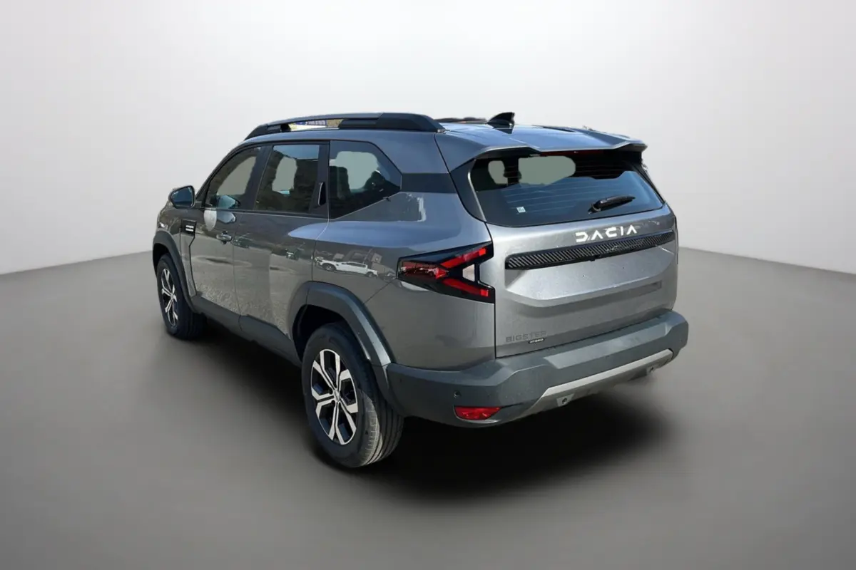 Vue 3/4 arrière droite du Dacia Bigster hybride gris schiste avec barres de toit et jantes alu 17 pouces.