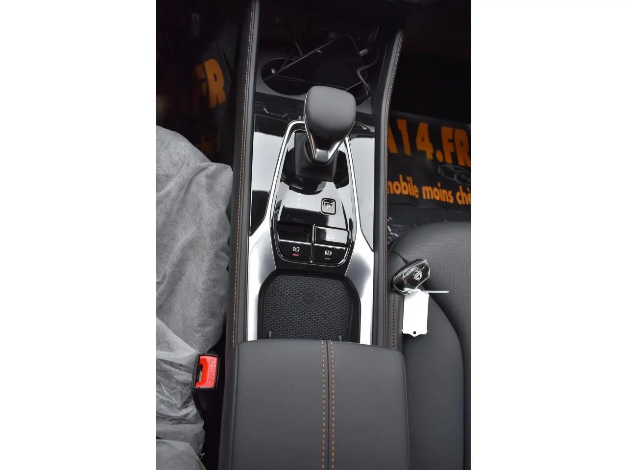 Vue plongeante sur la console centrale noire du MG Motor EHS avec levier de vitesse et clé posée sur le siège passager.