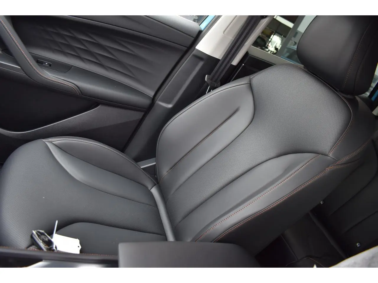 Gros plan sur le siège avant droit en cuir noir avec surpiqûres marron du MG MOTOR EHS 1.5 Hybrid+ 224 ch Luxury.