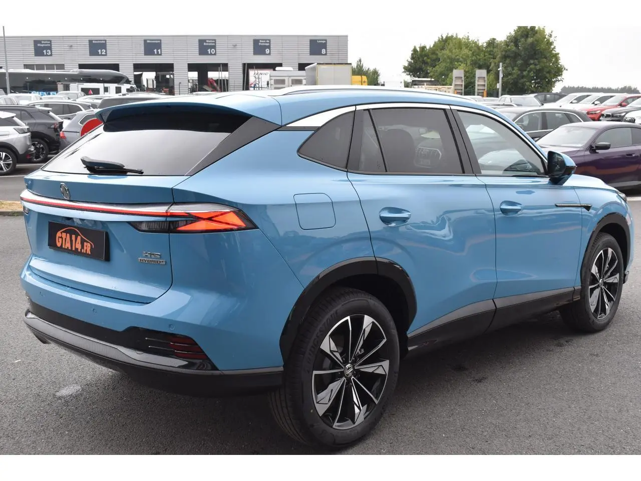 Vue 3/4 arrière droite du SUV MG EHS 1.5 Hybrid+ bleu avec jantes alliage 19 pouces et vitres surteintées.