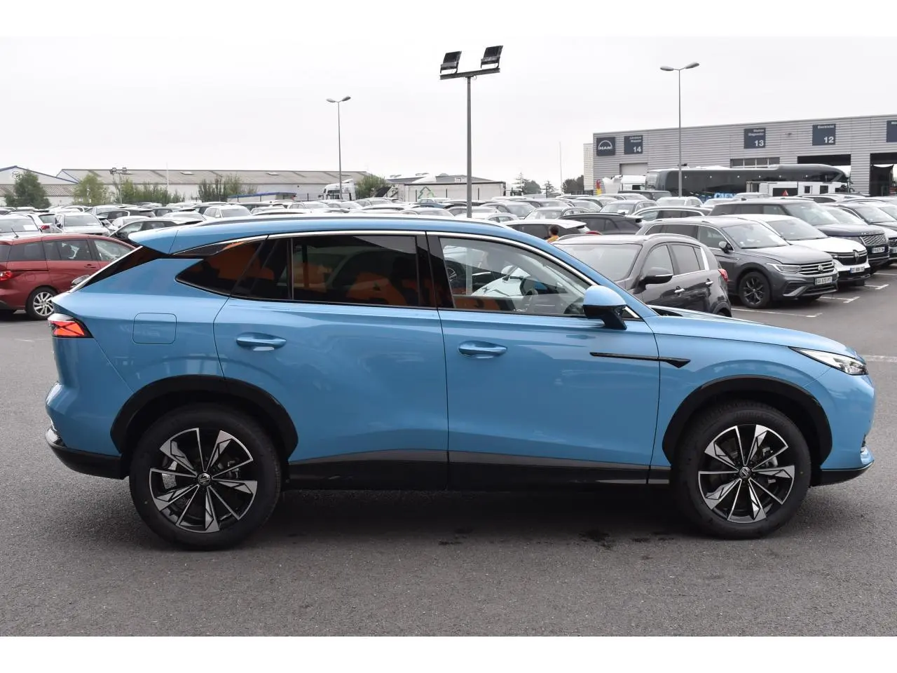 Vue de profil côté gauche du SUV MG EHS 1.5 Hybrid+ bleu avec jantes alliage 19 pouces et vitres surteintées.