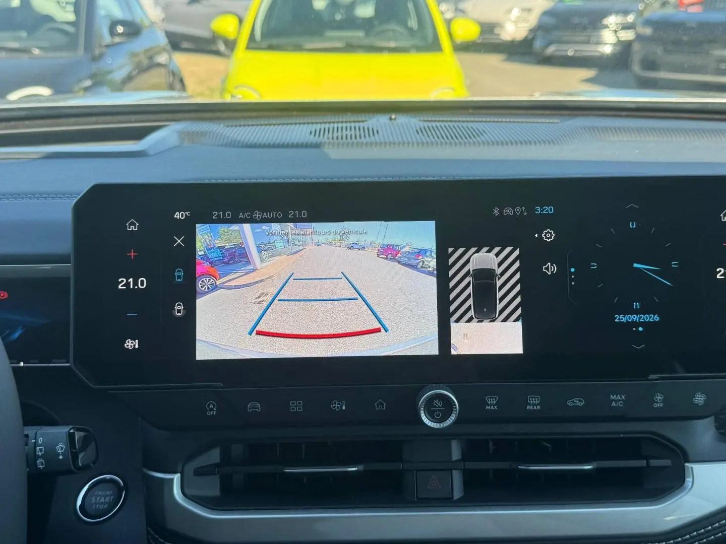 Vue intérieure du tableau de bord du Jeep Compass 2026 avec écran tactile affichant la caméra de recul et les commandes climatiques.