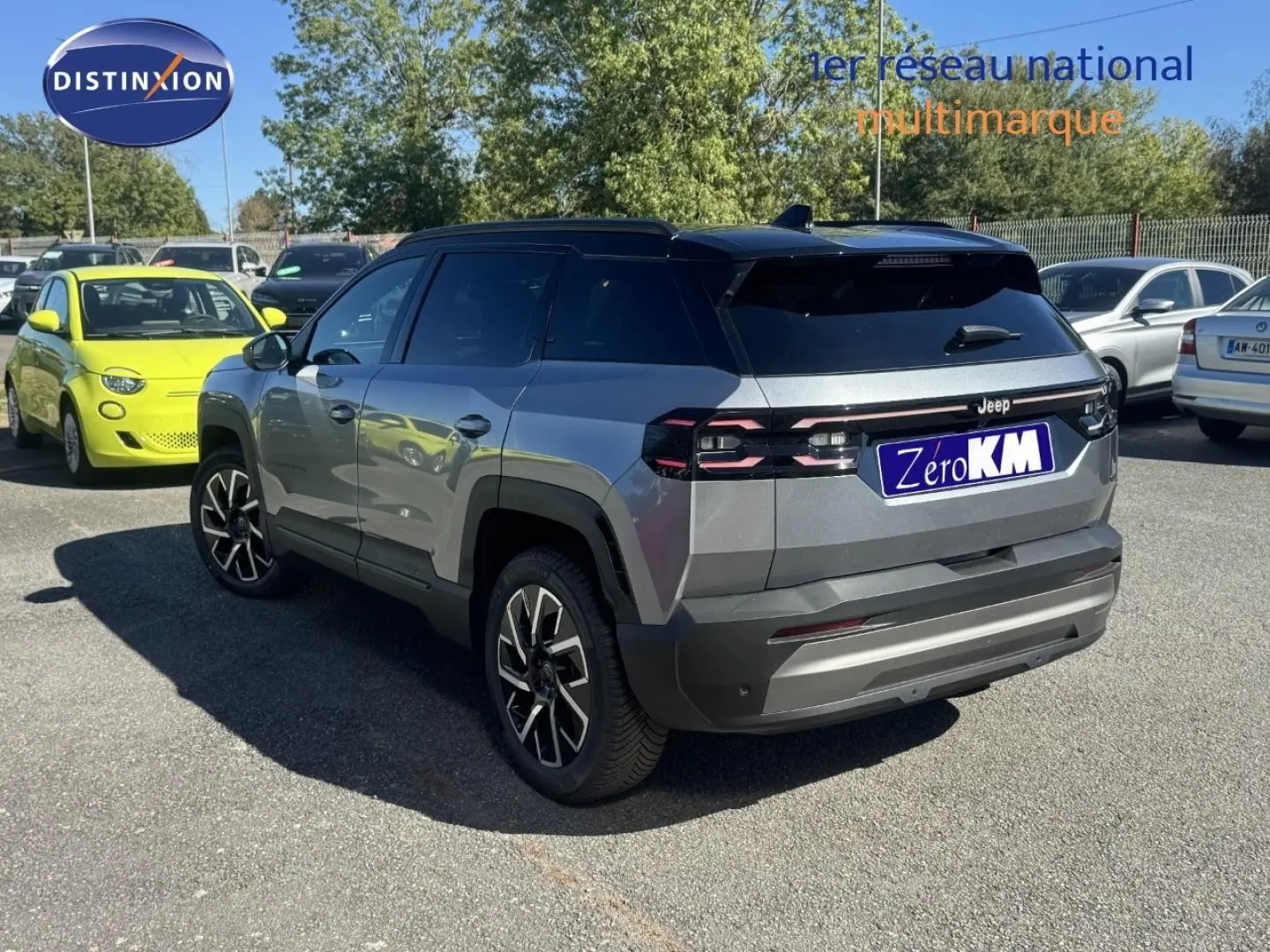 Vue 3/4 arrière droite d'un Jeep Compass Yosemite gris avec toit noir, jantes alu et feux arrière LED distinctifs.