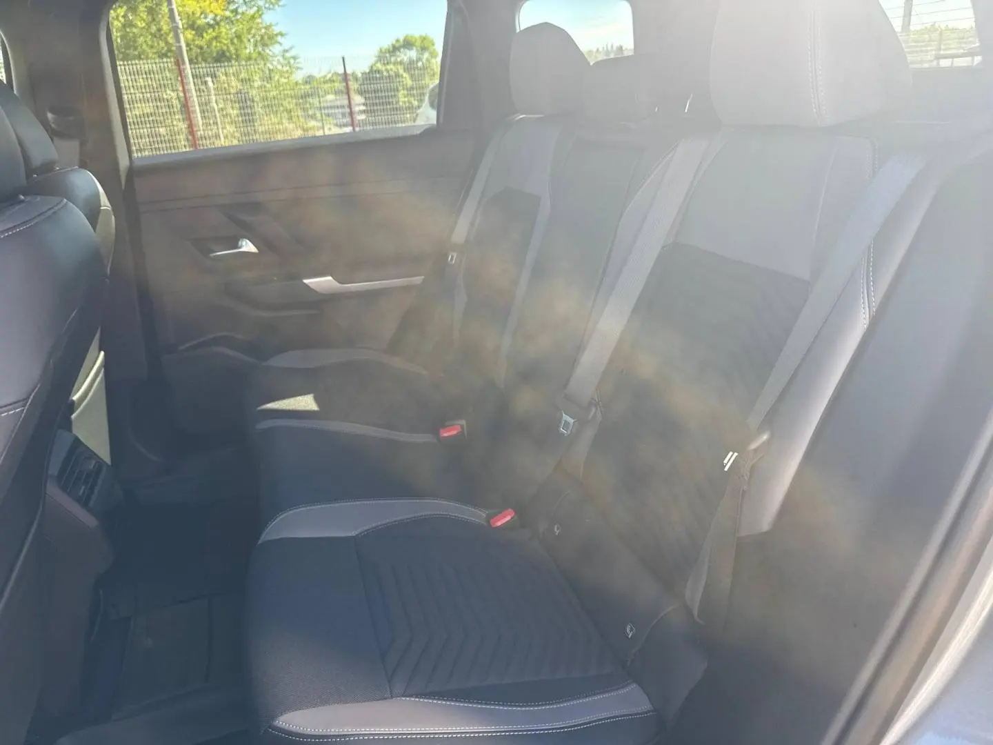 Vue intérieure côté droit sur la banquette arrière en tissu gris et noir du Jeep Compass 2026 avec ceinture de sécurité visible.