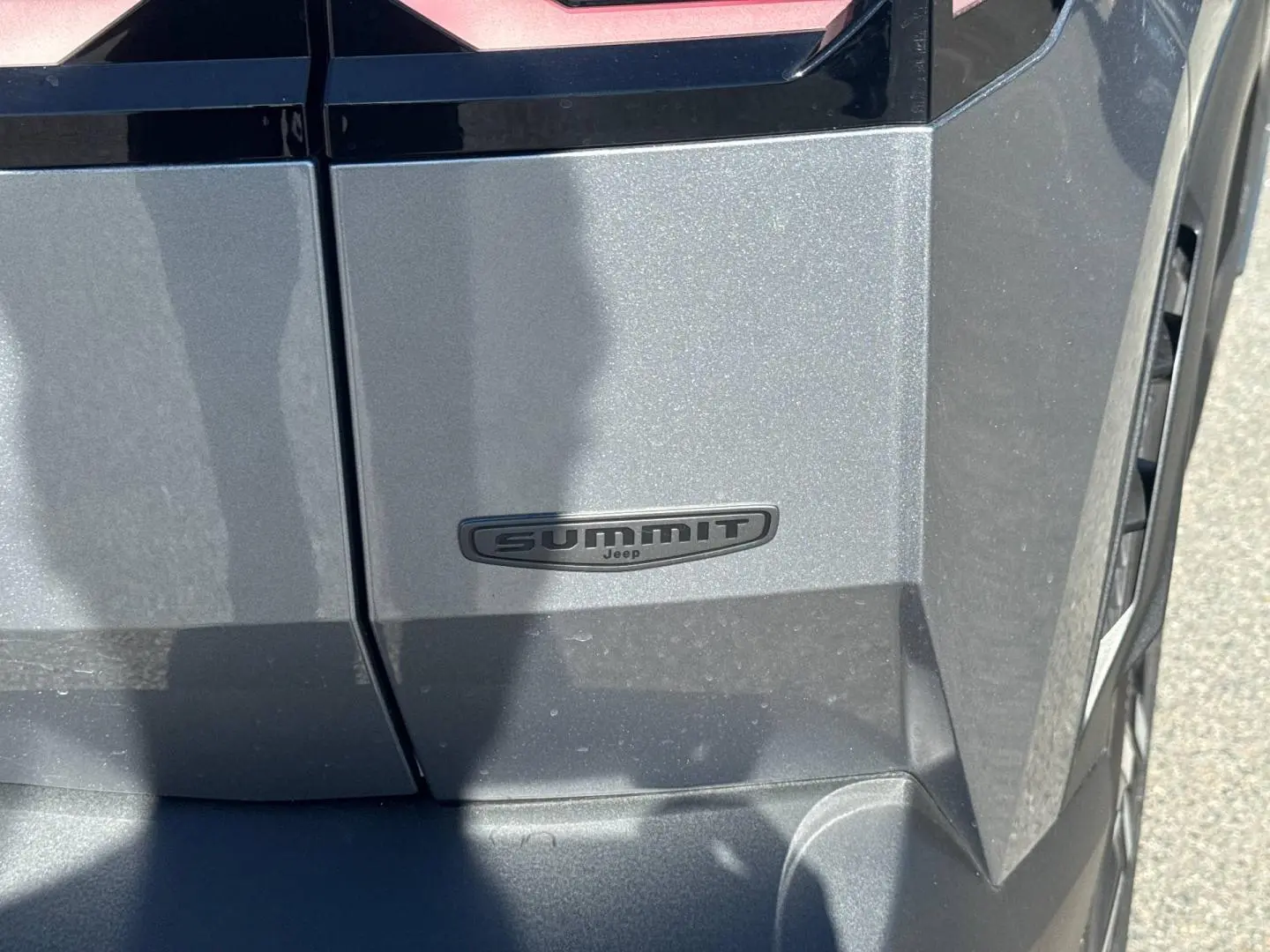 Gros plan sur l’emblème Summit côté droit d’un Jeep Compass 2026 gris Yosemite avec toit noir.