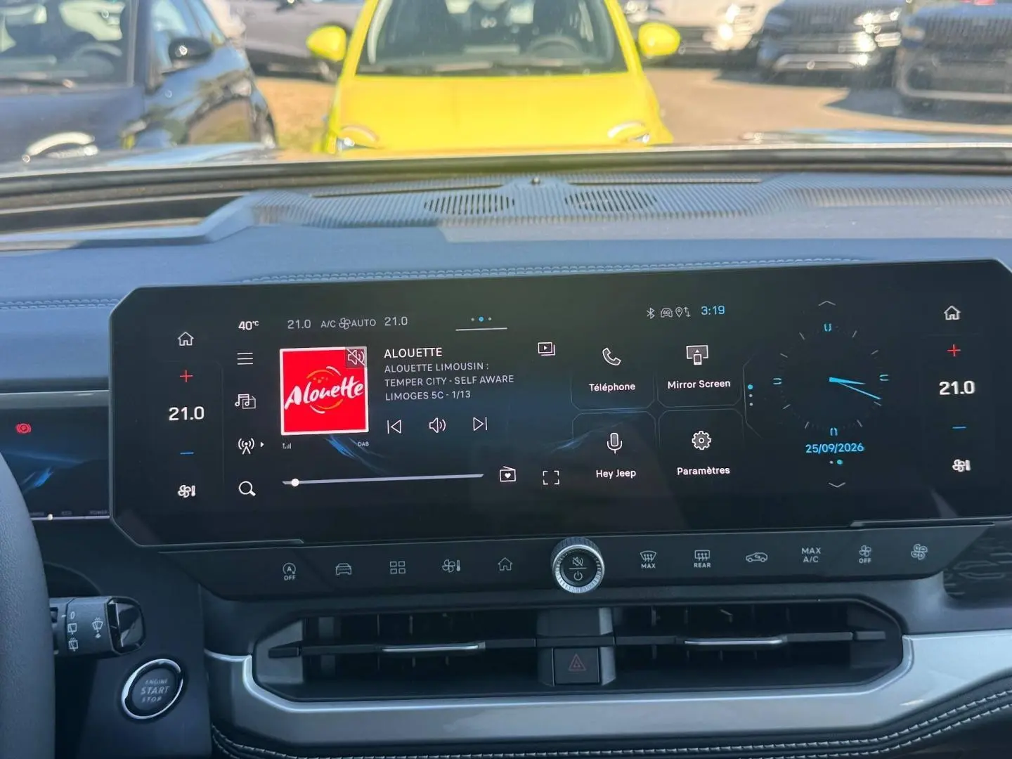 Vue intérieure du tableau de bord du Jeep Compass 2026 avec écran tactile large affichant la radio et la climatisation.