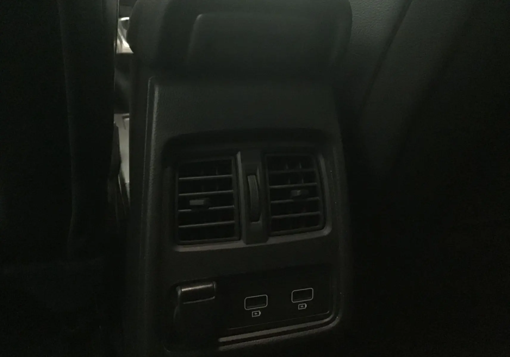 Détail des bouches d'aération arrière et ports USB du Renault Captur blanc nacré/noir, intérieur sombre.