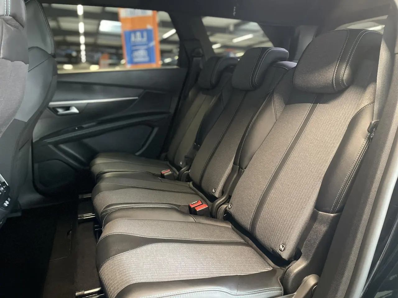 Vue latérale droite des trois sièges arrière indépendants en tissu et cuir noir du Peugeot 5008 2024 finition Allure Pack.