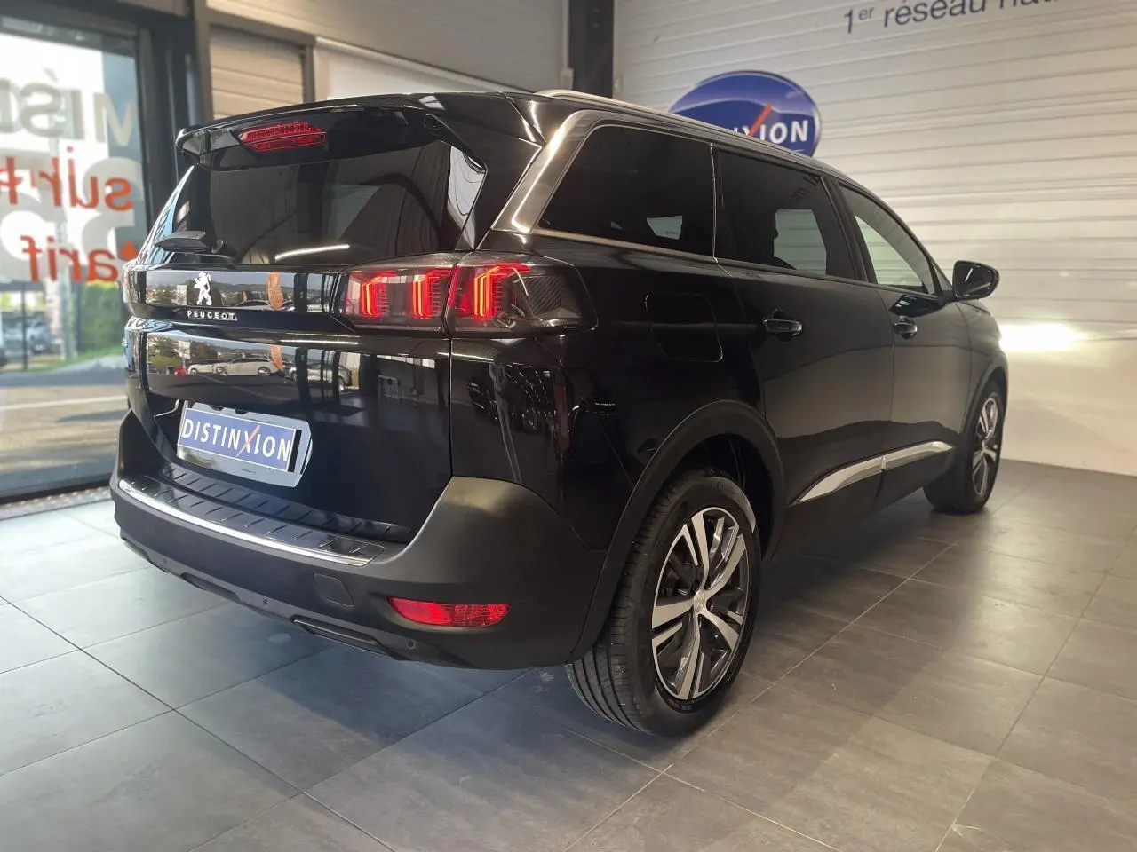 Peugeot 5008 noir métallisé vue 3/4 arrière droit avec feux arrière LED 3D et jantes alliage bi-ton.