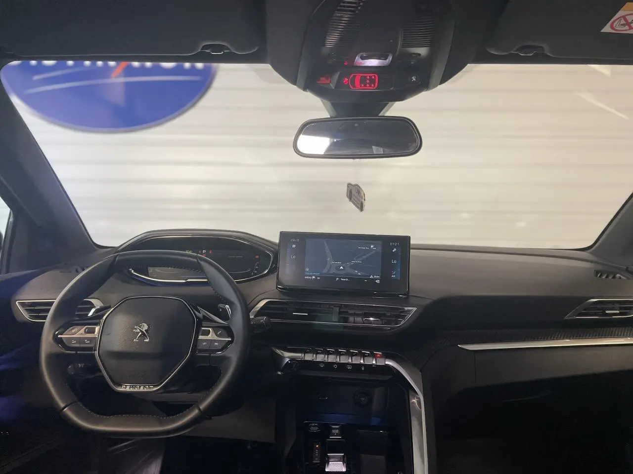 Intérieur noir du Peugeot 5008 2024, vue frontale du tableau de bord avec écran tactile et volant compact multi-fonctions.