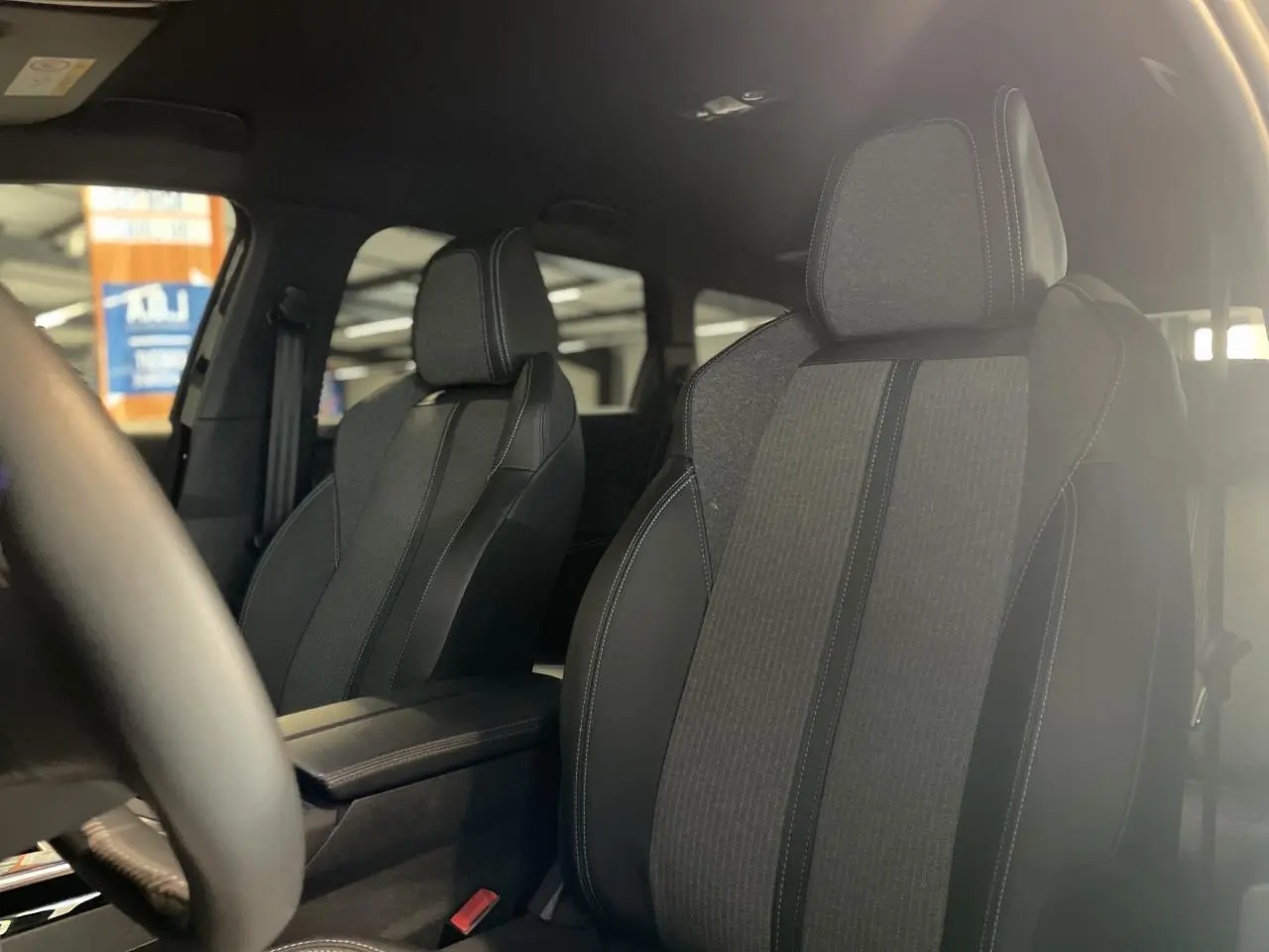 Gros plan sur les sièges avant en TEP et tissu Colyn du Peugeot 5008 2024, ambiance intérieure noire Mistral.