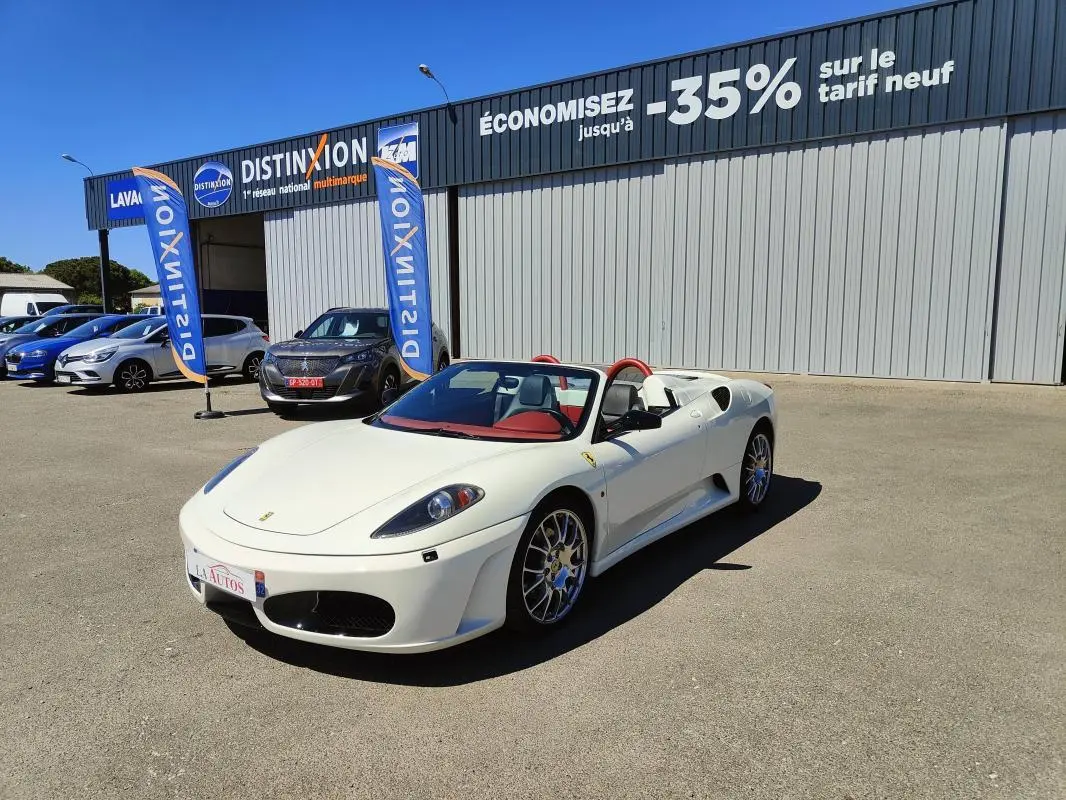 Ferrari F430 Spider blanc 60ème anniversaire vue 3/4 avant avec intérieur rouge et capote ouverte.