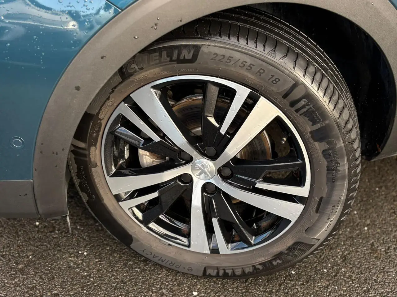 Gros plan sur la jante alliage 18 pouces bi-ton noir et argent du côté gauche d'un Peugeot 3008 Bleu Célèbes.