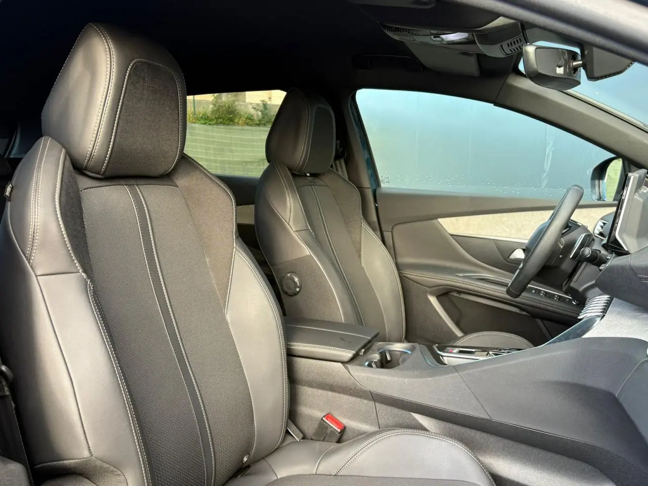 Vue intérieure avant du Peugeot 3008 2023, sièges Mi-TEP/tissu Belomka gris avec accoudoir central ouvert.