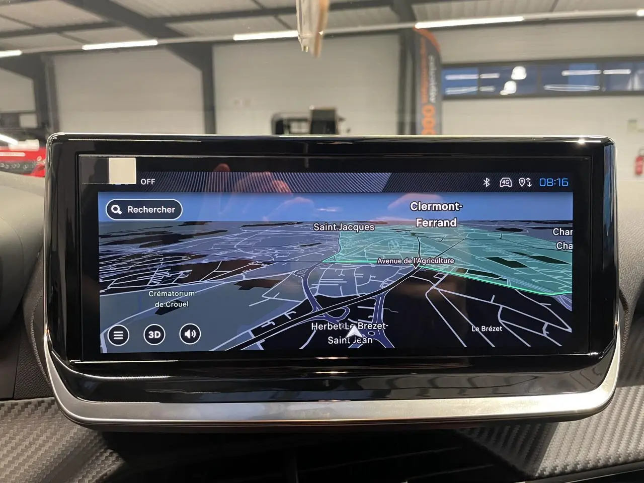 Écran tactile central du tableau de bord de la Peugeot 208 gris Selenium affichant la navigation GPS en 3D.