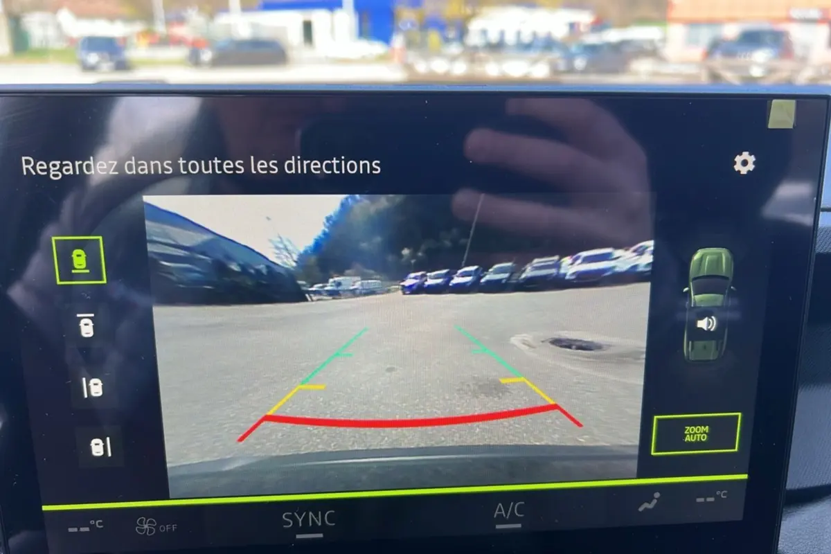 Écran de caméra multiview montrant la vue arrière du parking, interface du DACIA BIGSTER vert cèdre hybride 2026.