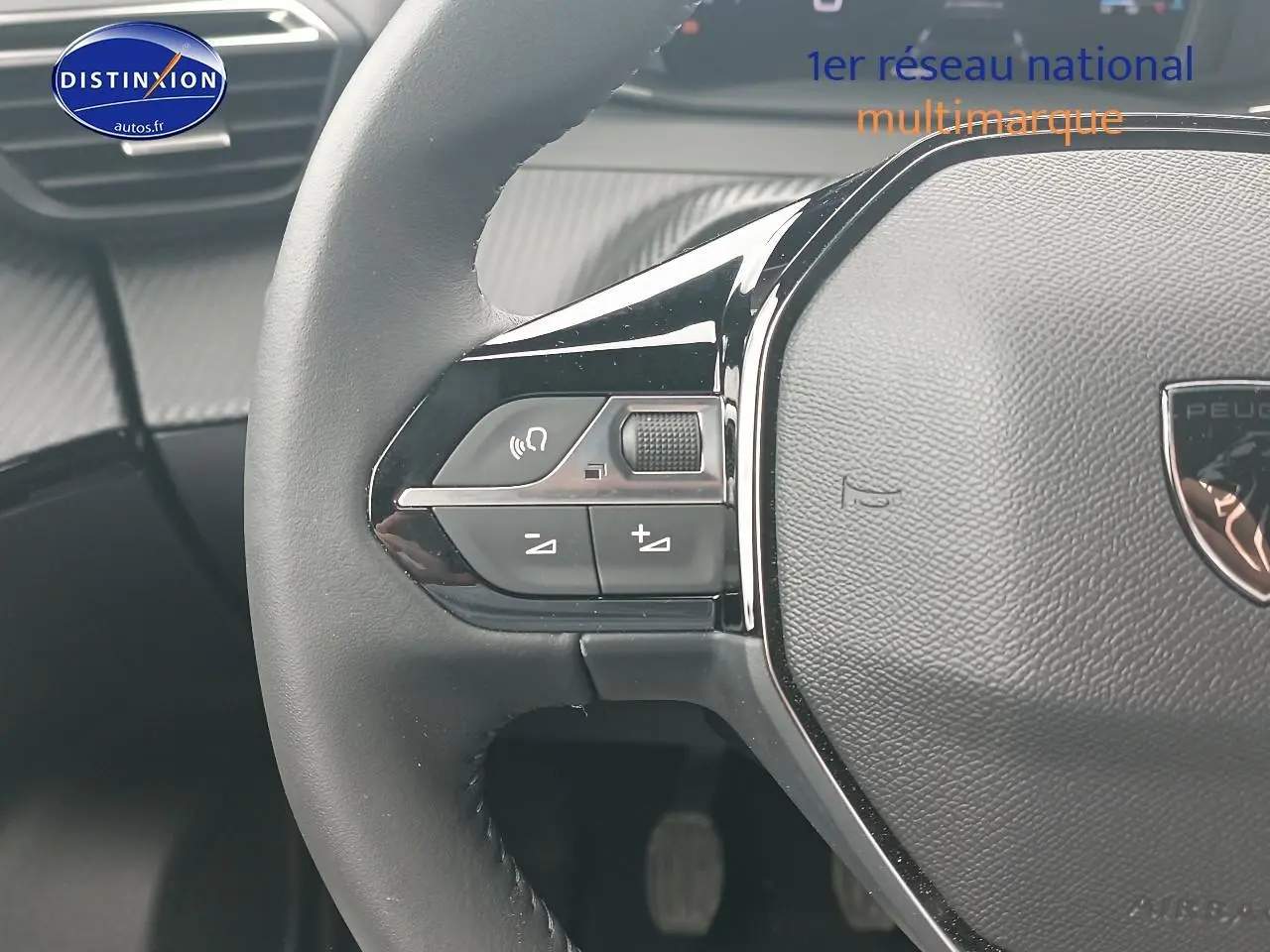 Gros plan sur le volant multifonction noir du Peugeot 2008 1.2 100 allure avec commandes audio intégrées.
