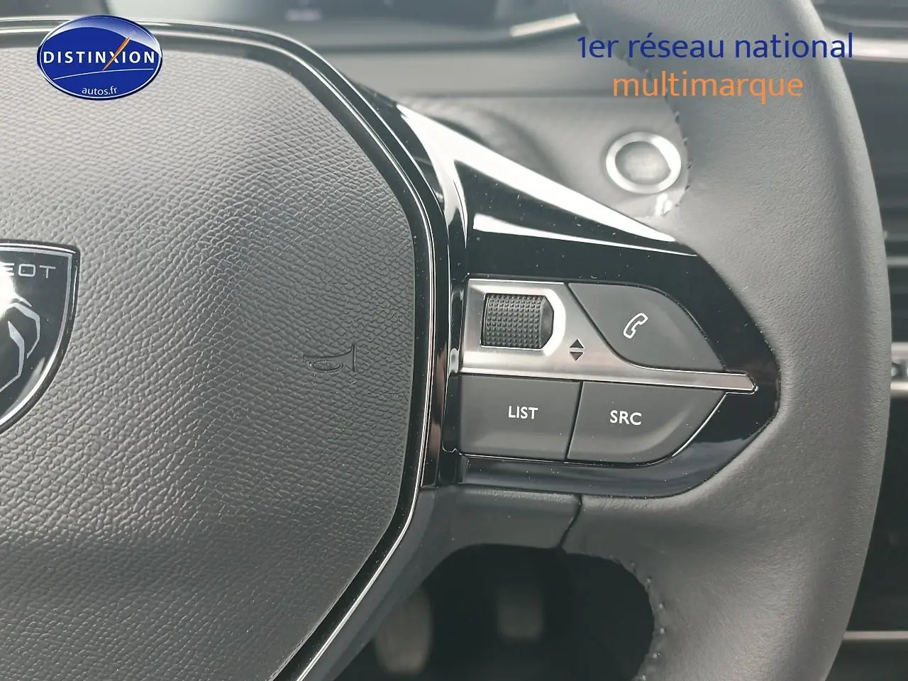 Gros plan sur le volant multifonction noir de la Peugeot 2008 1.2 100 allure, avec commandes audio et téléphone.