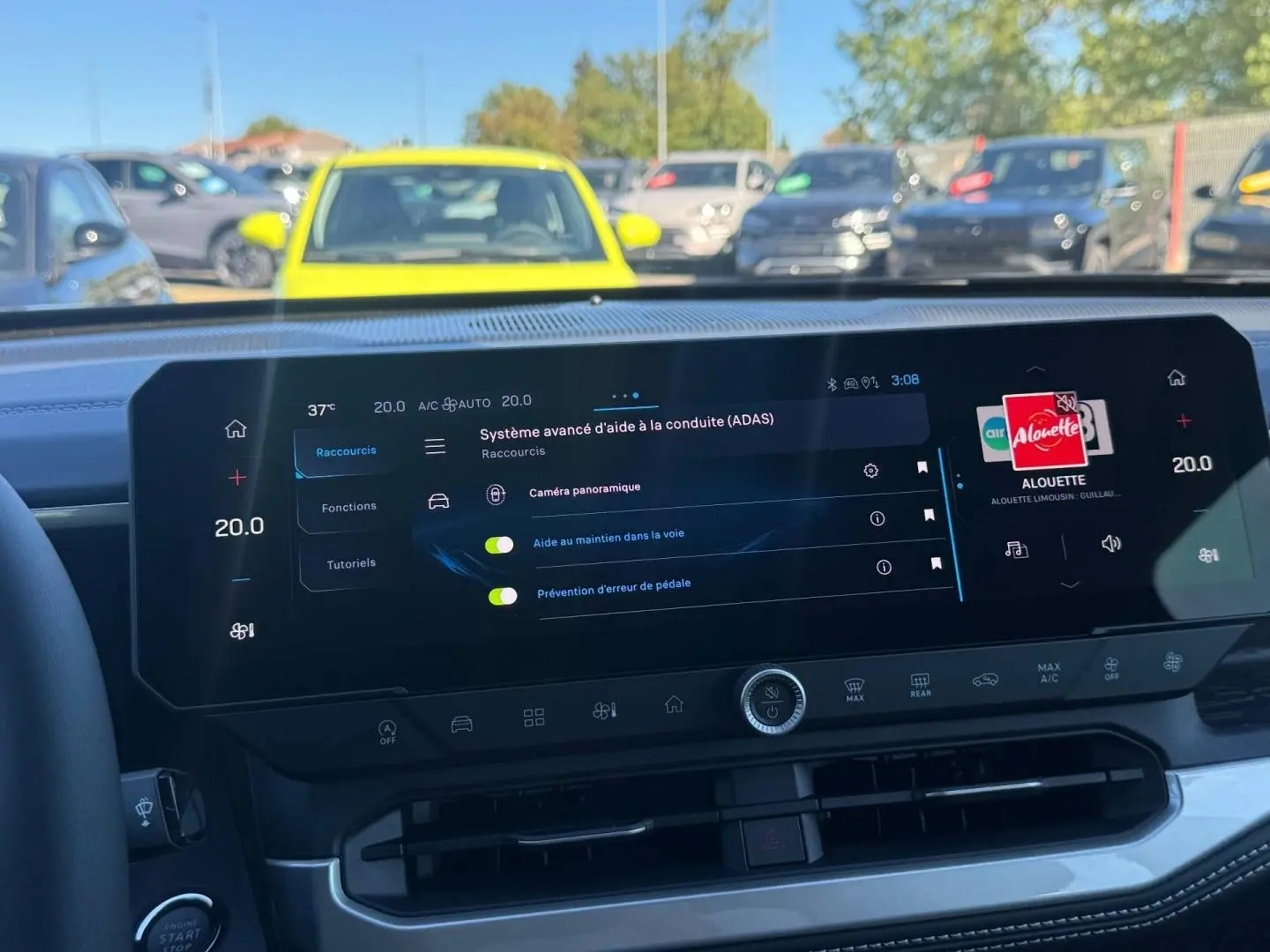 Vue intérieure du tableau de bord du Jeep Compass 2026, écran tactile affichant les aides à la conduite, volant partiellement visible.
