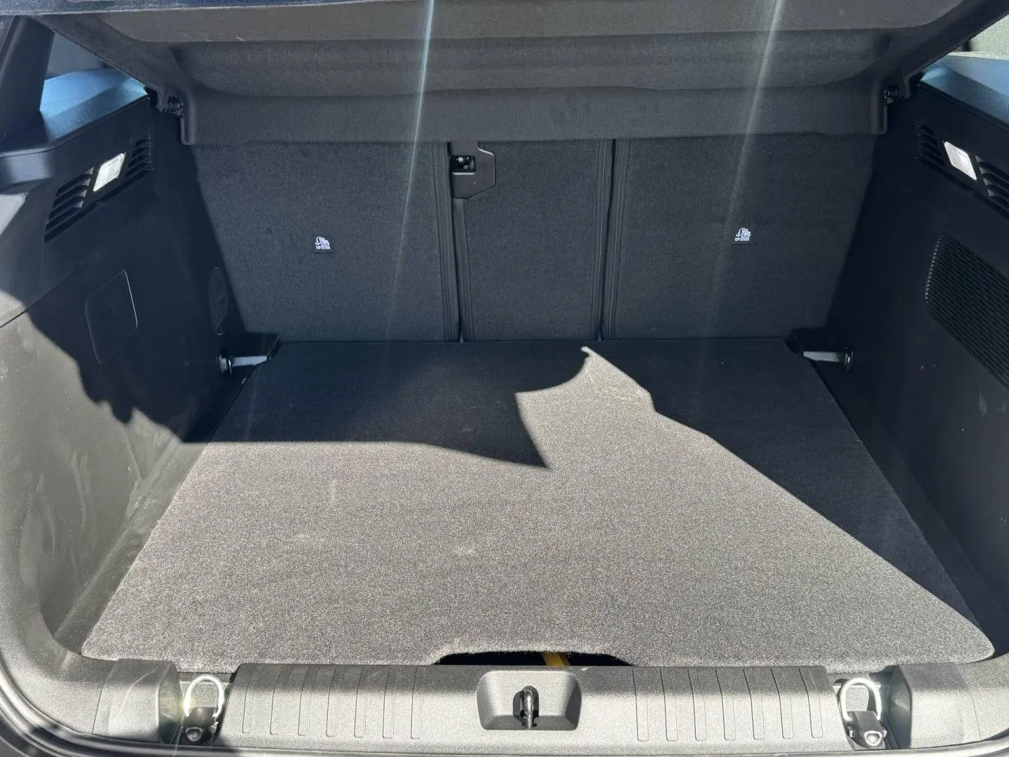 Coffre ouvert vu de l'arrière du Jeep Compass 2026, espace de chargement propre avec tapis noir et habillage sombre.