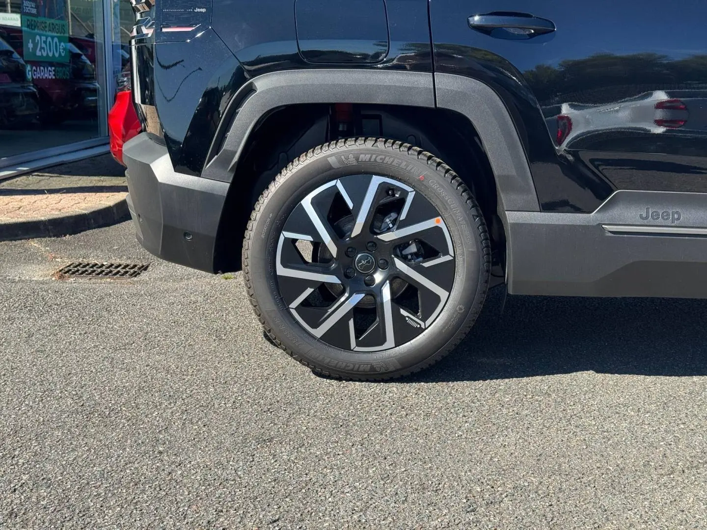 Gros plan sur la roue arrière gauche du Jeep Compass Vulcano 2026 avec jante alu et logo Jeep sur la porte.