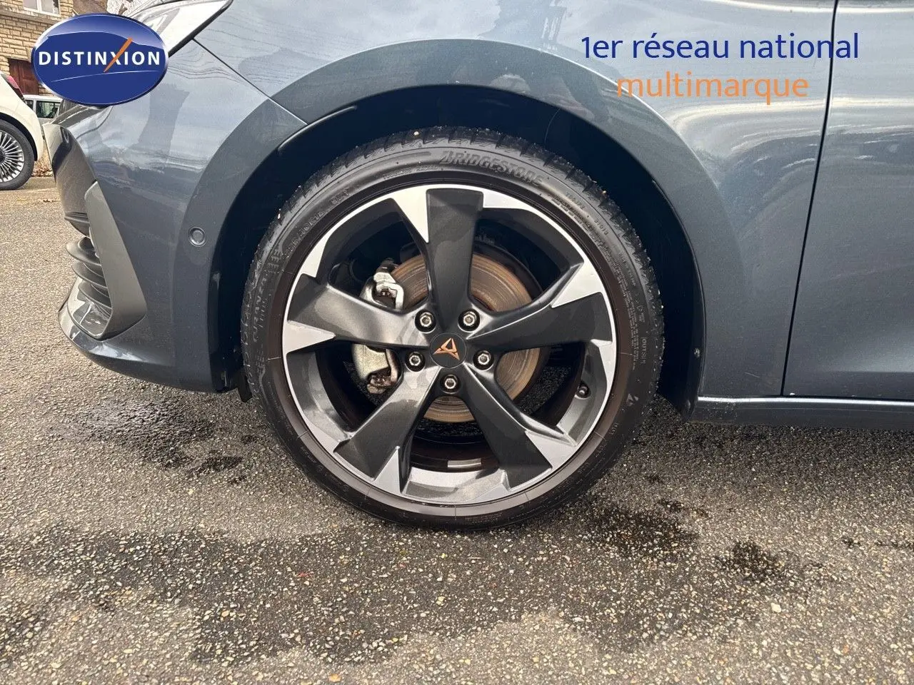 Gros plan sur la roue avant gauche de la CUPRA LEON ST 2024 gris magnetic metal avec jante alliage bicolore distinctive.
